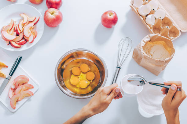 istock Woman's hands measuring cup of sugar to mix it with eggs 1004213220