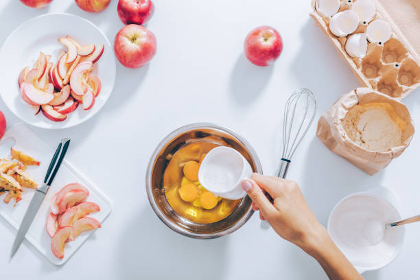 istock Cooking apple pie process: woman add sugar into bowl 1004213226