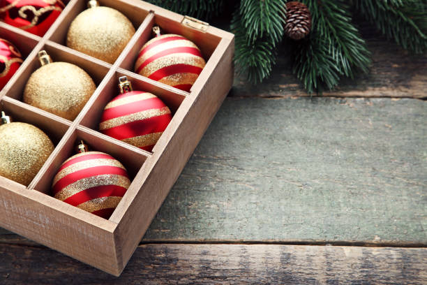 istock Golden and red christmas baubles in crate with fir-tree branches 1004216472