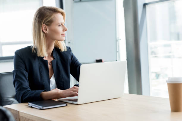 istock pensive businesswoman looking away while using laptop at workplace 1004217018