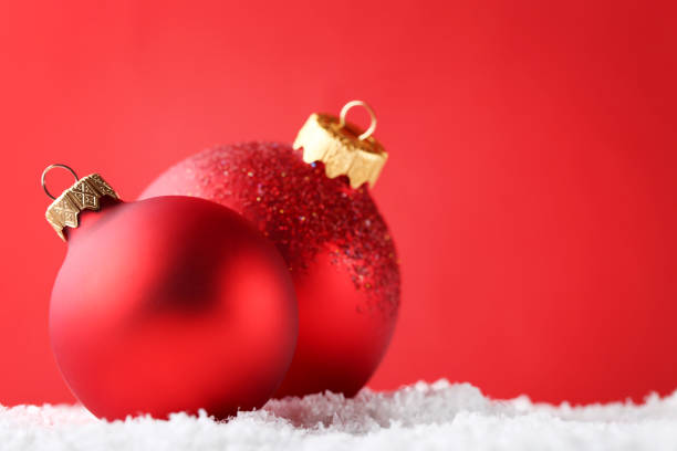 istock Red christmas baubles on white snow 1004222564