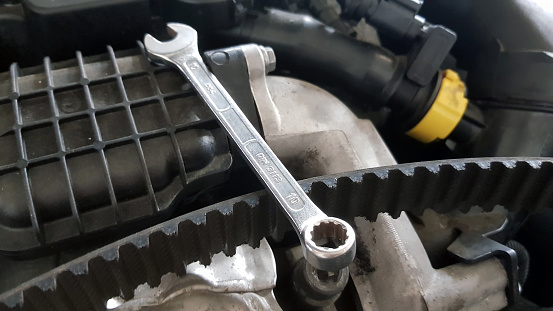 Spanner and timing belt on car engine ready for service repair