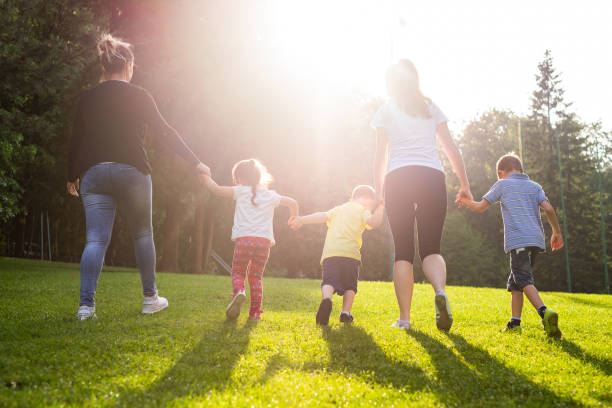 istock Back view two women walking on the hill with kids 1004227054
