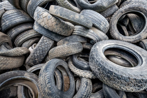 istock Old broken car tires piled up to a mountain as a background 1004227802