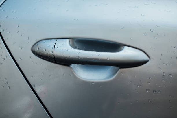 istock Handle on door of modern car. Rainy water drops on automobile 1004230652