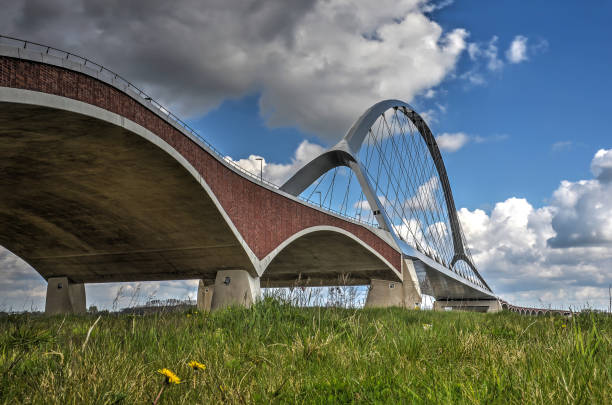 New city bridge De Oversteek The concrete, brick and steel arches of new city bridge De Oversteek (The Crossing) across the river Waal near Nijmegen, the Netherlands bridge crossing cloud built structure stock pictures, royalty-free photos & images