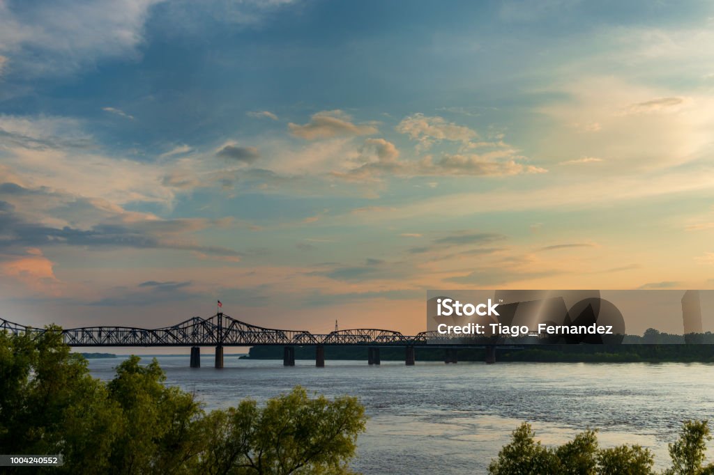 View of the Mississippi River with the Vicksburg Bridge on the background at sunset; View of the Mississippi River with the Vicksburg Bridge on the background at sunset; Concept for travel in the USA and visit Mississippi Vicksburg Stock Photo