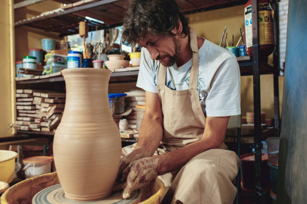 istock Creating a jar or vase of white clay close-up. Master crock 1004240590