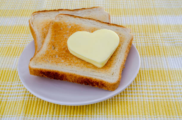 istock two toasts with heart shaped butter on a yellow tablecloth 1004248000