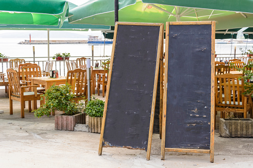 two blank blackboard against chairs and umbrellas