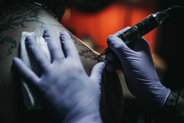 istock Tattoo artist making tattoo on a men’s shoulder 1004253684