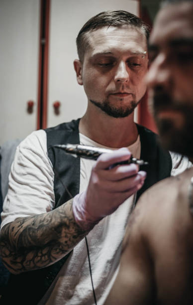 istock Tattoo master making tattoo on customer's shoulder 1004253800