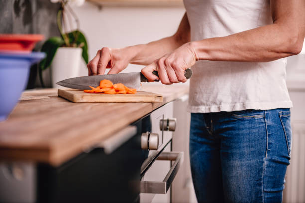 istock Woman cutting carrot 1004255100
