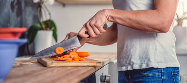 istock Woman cutting carrot 1004257668
