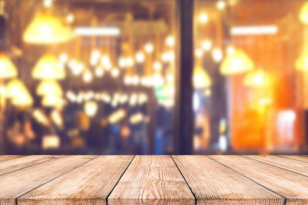 istock Empty wood table top with blurred light bokeh in night cafe restaurant background 1004259688