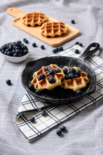 istock Homemade Waffles blueberries and icing on a dish that looks like a pan. 1004263652