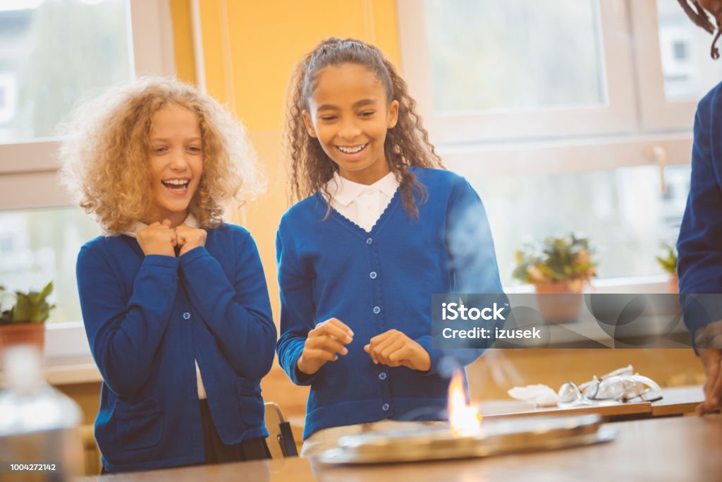 Amazed students looking at chemical reaction in science class Excited little kids looking at chemical experiment in laboratory. School children looking at chemical reaction in class and smiling. Education Stock Photo