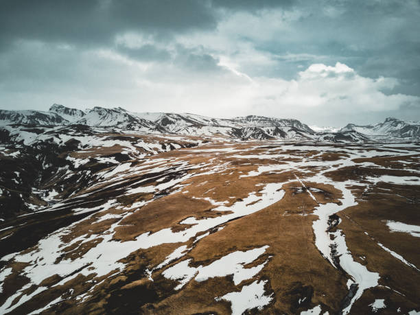 исландия вид с воздуха пейзаж со снегом и облаками, улица и желтая и зеленая трава - arctic circle wintry landscape mountain mountain range стоковые фото и изображения