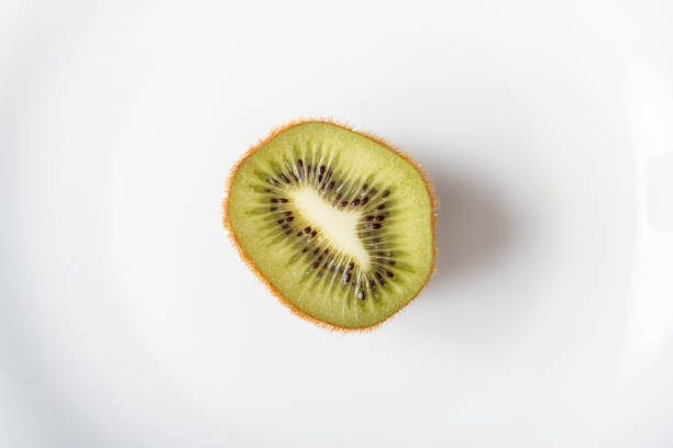 istock Fresh organic kiwi fruits on white background. White plate with fresh fruit closeup. Copy space. Natural healthy food concept 1004280558