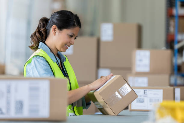 distribution warehouse employee prepares package - post processing imagens e fotografias de stock