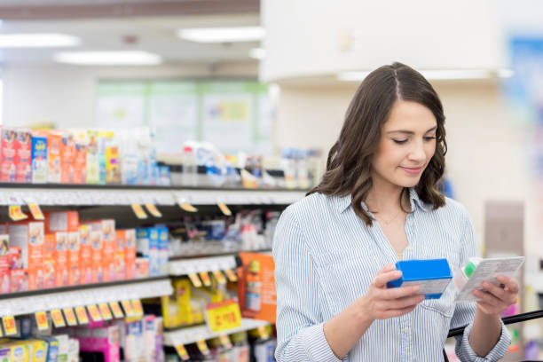 istock Young woman compares medicine labels in pharmacy 1004304000