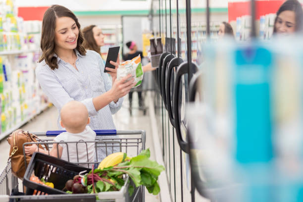 mladá matka fotografuje etiketu potravin v obchodě s potravinami - mražené jídlo fotky - stock snímky, obrázky a fotky