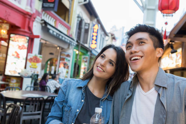 istock Young couple choose sidewalk cafe in Singapore 1004304050