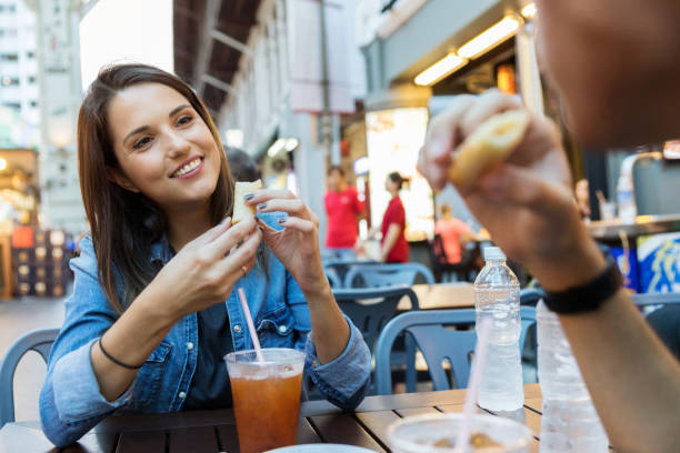 istock Young woman enjoys sidewalk cafe date 1004304078