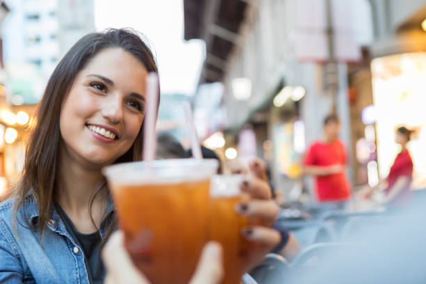 istock Young woman toasts in celebration at sidewalk cafe 1004304080