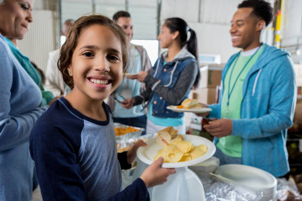 menina recebe refeição durante viagem de caridade de banco de alimentos - homelessness food in a row people - fotografias e filmes do acervo