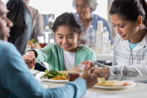 istock Family prays together before soup kitchen meal 1004308618