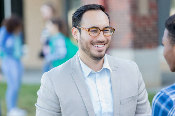 istock Confident high school teacher talking with student 1004308970