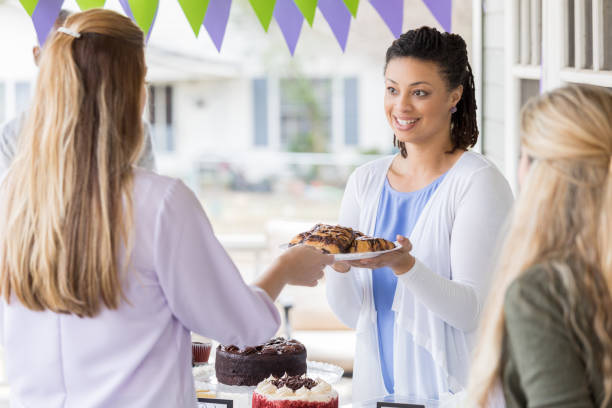 istock Customer buys dessert at charity bake sale 1004309156