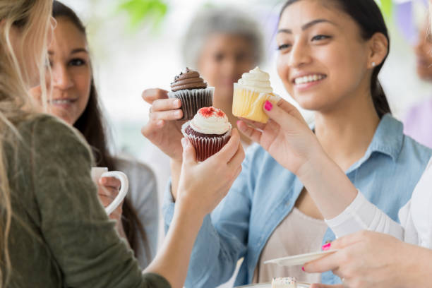 istock Friends 'toast' cupcakes during birthday party 1004309264