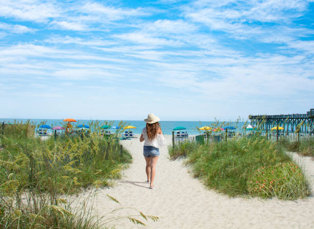 istock Woman waking on the beach on summer vacation.. 1004315166