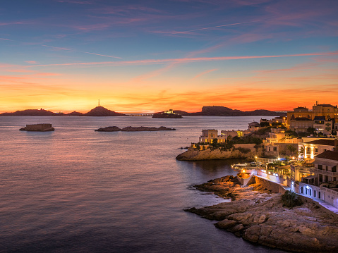 An image capturing the serene beauty of the sunset at Benirras Beach in Ibiza, where the sky transitions through a palette of vibrant colours, reflecting off the calm Mediterranean waters. This peaceful scene is a beloved spectacle, drawing visitors to experience the tranquil and magical end to the day on one of Ibiza's most iconic beaches.