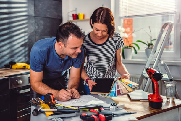 пара глядя на цвет swatch во время ремонта кухни - home decorating interior designer blueprint planning стоковые фото и изображения