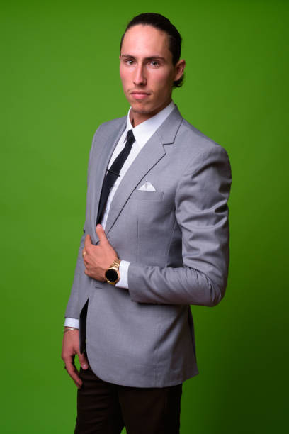 istock Young handsome businessman against green background 1004352648