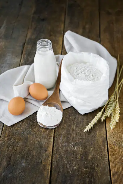 milk, eggs, flour and kitchen tools on wooden table