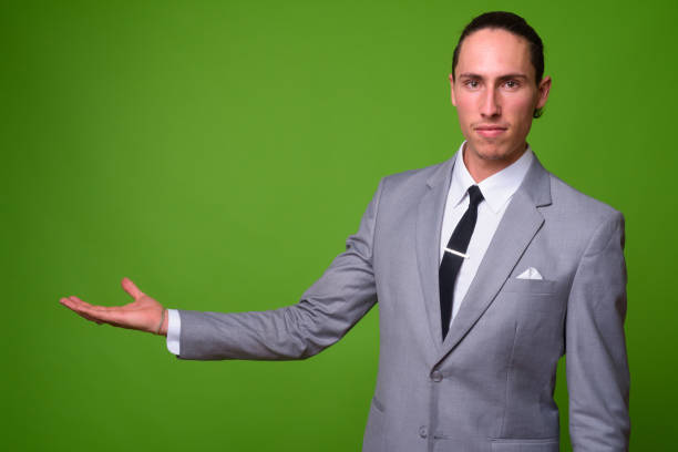 istock Young handsome businessman against green background 1004377070