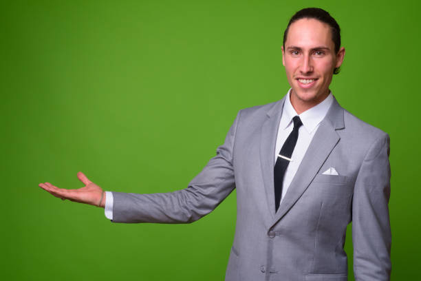 istock Young handsome businessman against green background 1004380980