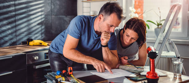 pareja mirando planos durante la renovación de la cocina - blueprint plan house home improvement fotografías e imágenes de stock