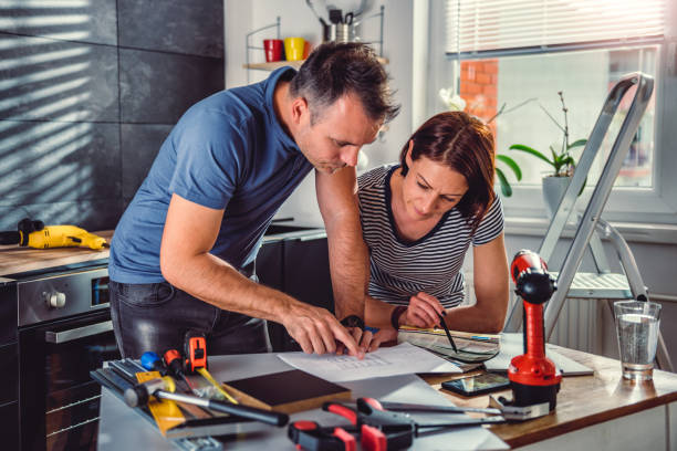 istock Couple looking at blueprints during kitchen renovation 1004381320
