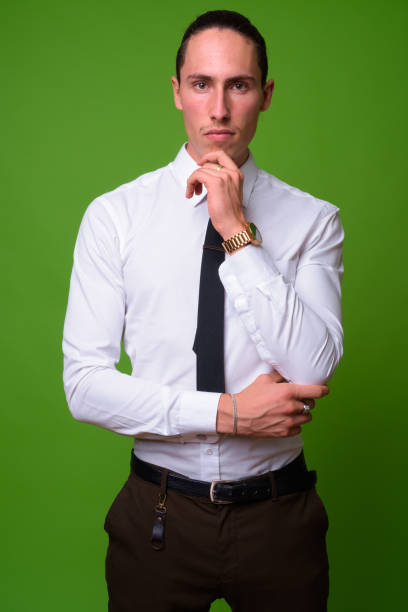 istock Young handsome businessman against green background 1004393124