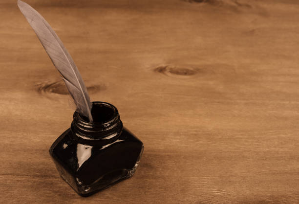 istock Inkwell with a feather as a quill pen on a wooden background 1004399262