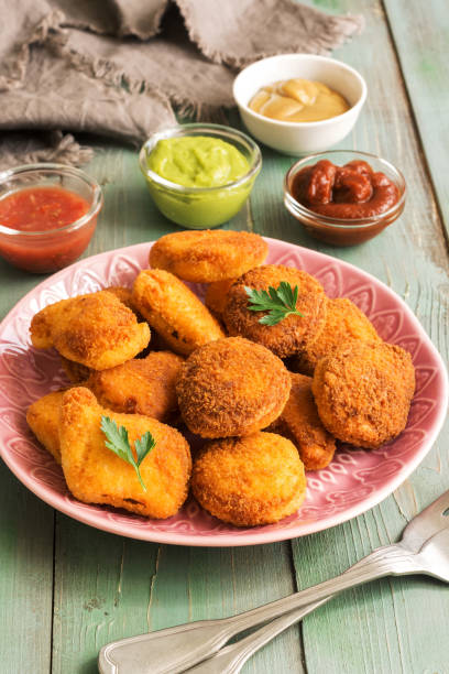 istock Chicken nuggets with sauces on a rustic green wooden background. selective focus. 1004435374