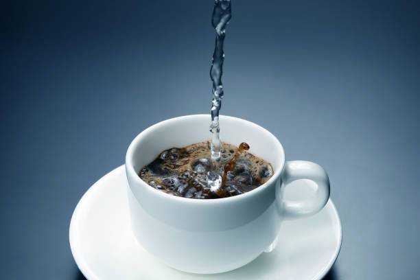 istock boiled water is poured into a white cup with black coffee 1004435582