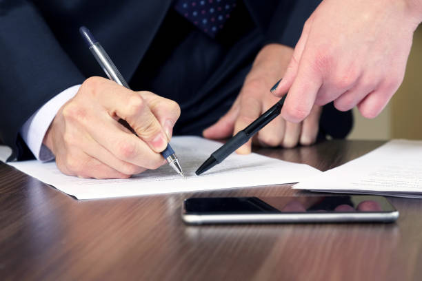 istock hands of business men and women studying the documents 1004436436