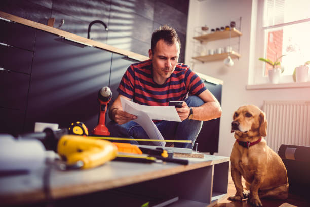 istock Man with dog checking blueprints and using smart phone 1004448822