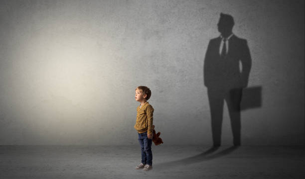 istock Little boy with businessman shadow 1004452848